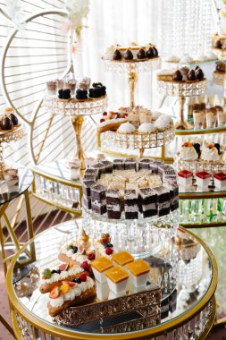 Şatafatlı bir büfe, çeşitli lezzetli hamur işleri, badem kurabiyeleri ve tatlılar sergileniyor, zarif ve cezbedici bir tatlı gösterisi yaratıyor.