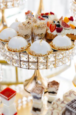 Şatafatlı bir büfe, çeşitli lezzetli hamur işleri, badem kurabiyeleri ve tatlılar sergileniyor, zarif ve cezbedici bir tatlı gösterisi yaratıyor.