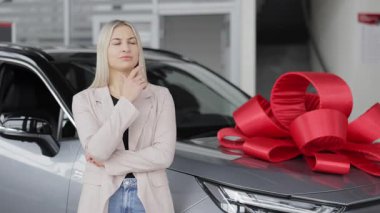 Galeride yeni bir araba seçen düşünceli bir iş kadını.