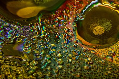 Renkli bir arkaplanda, makro fotoğraf çekiminde suya yağ damlaları.