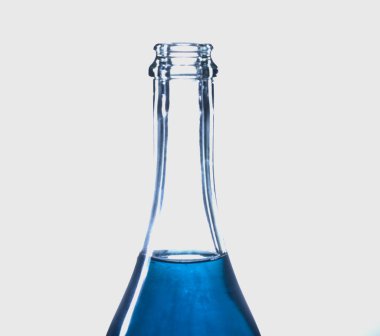 Mavi sıvıyla şeffaf bir şişenin makro çekimi.