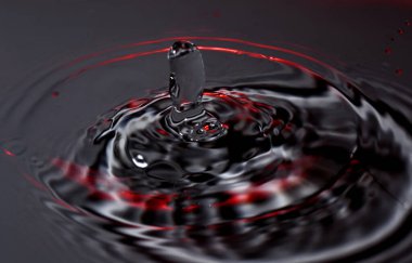 Su damlası - su yüzeyine renkli makro bir çekimle düşen bir damla