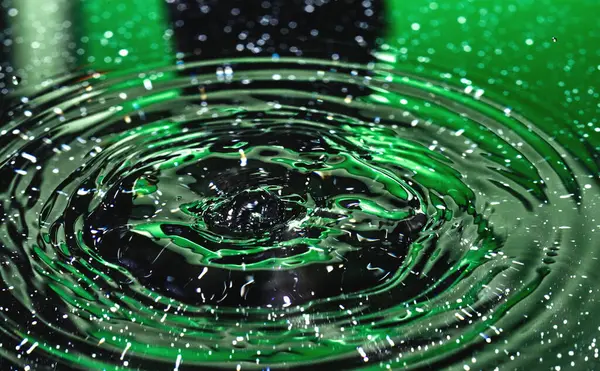 Su sıçratma - renkli makro karede düşen bir su damlası