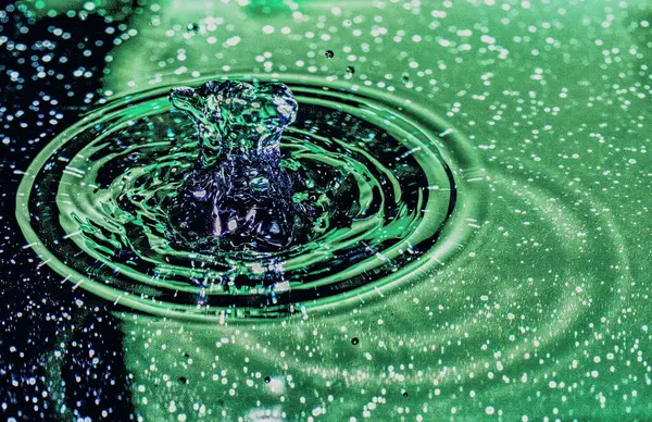 Su sıçratma - renkli makro karede düşen bir su damlası