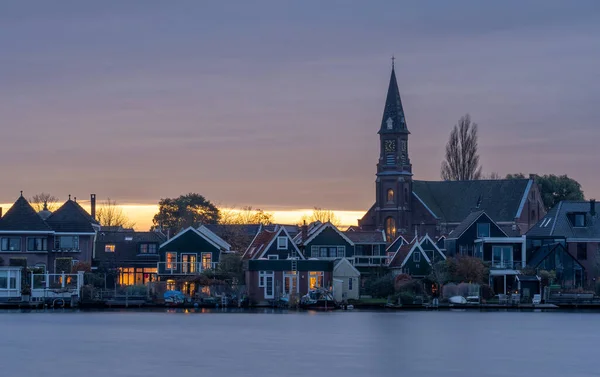 在Zaandijk镇的教堂日落时分 从Zaandam看到的前景是Zaan河 — 图库照片