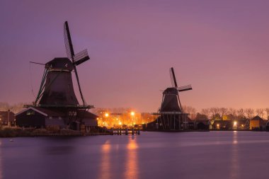 Günbatımında Zaanse Schans 'da geleneksel yel değirmenleri