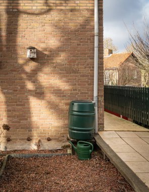 Rain barrel connected to the gutter, rain water harvesting and reusage 