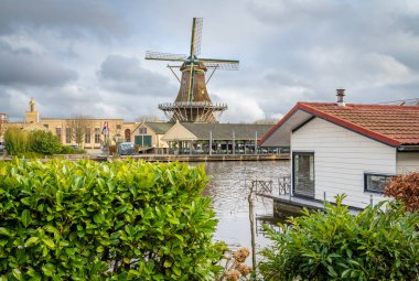 Historical windmill along the Rhine river in dutch city of Leiden, Province South Holland