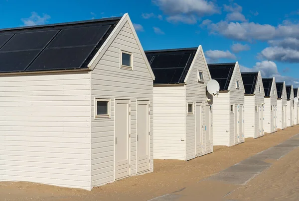 stock image Row of white wooden beach houses with solar panels at seaside resort Katwijk aan Zee