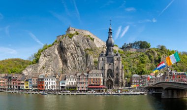 Dinant, Belçika, 04.05.2023, Meuse nehrinin kıyısında ünlü kale ve gotik kolej kilisesi olan Dinant Panoraması.