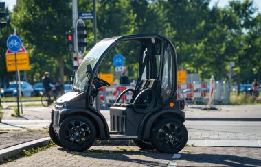 Amsterdam, Hollanda, 06.09.2023, Kapısız elektrikli iki koltuklu mikro araba Bir Estrima sokağa park edilmiş.
