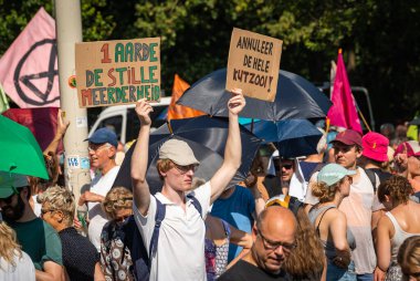Lahey, Hollanda, 09.09.2023, Fosil yakıt sübvansiyonlarına karşı düzenlenen protesto eylemi sırasında Lahey 'deki A12 karayolunu engelleyen pankartlı İklim aktivistleri