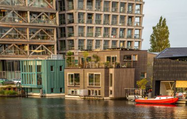 Amsterdam, Hollanda, 16.08.2023, Amsterdam 'ın yaratıcı kuzeyinde sürdürülebilir yüzen topluluk okulunda modern evler