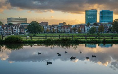 Skyline of Arnhem seen from the pond at Sonsbeek park at dusk clipart