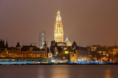 Antwerp, Belçika 'nın silüeti. Hanımefendinin Katedrali manzarası ve Scheldt nehri akşam ön planda.