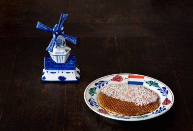 Tabağında Hollanda bayrağı olan bir stroopwafel, Hollanda 'da popüler olan yuvarlak waffle kurabiyesi.
