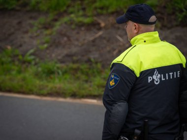 Amsterdam, Hollanda, 30.03.2024, Hollandalı polis memurunun sokaktaki arka görüntüsü