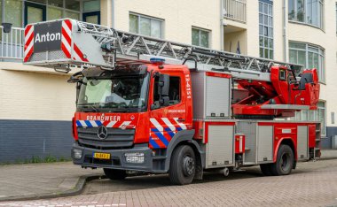Amsterdam, Hollanda, 04.05.2024, Hollandalı itfaiye aracı Mercedes Benz Atego. Sokakta merdivenli itfaiye aracı var.