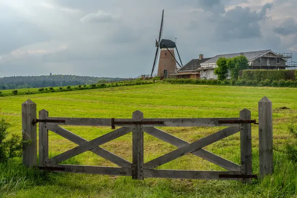 スタッカムの村でダッフェルズMllとして知られている伝統的なオランダの風車とバックグラウンドの時計塔モンファーランド ストック写真