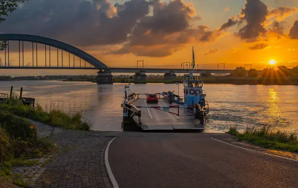 stock image Landscape of Culemborg by sunset, view of the bridge over the Lek river and ferry crossing