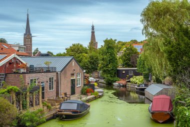 Cityscape of Medemblik, North Holland, The Netherlands. Church towers seen from the canal clipart