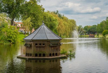 Public park in the city of Culemborg with birdhouse on the water clipart