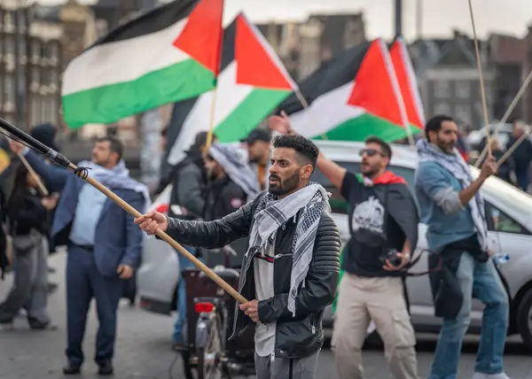 Amsterdam, Hollanda, 13.10.2024, Pro 'da protestocu - Amsterdam merkez tren istasyonu önünde Filistin protestosu
