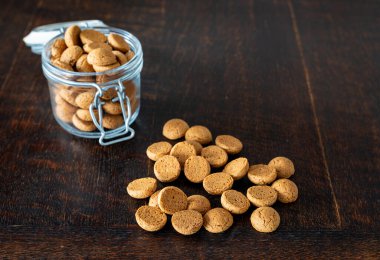 Kruidnoten on wooden table, typical dutch cookie made of speculaas and  traditionally associated with Sinterklaas clipart