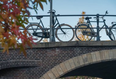 Kanal kenarındaki Hollandalı motosikletli sonbahar manzarası