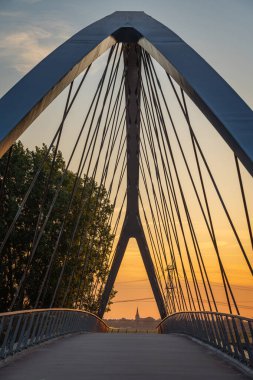 Nigtevecht 'teki Liniebrug köprüsünün simetrik görüntüsü ve Hollanda, Abcoude' deki kilise kulesi, gün batımına kadar.