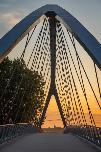 Nigtevecht 'teki Liniebrug köprüsünün simetrik görüntüsü ve Hollanda, Abcoude' deki kilise kulesi, gün batımına kadar.