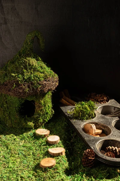 Fairy garden.  Old muffin tin full of supplies to add tiny special touches to a miniature fairy scene. Vertical orientation.