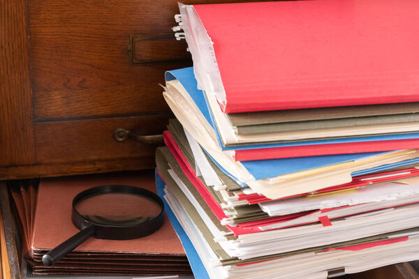 Stack of file folders on an antique cabinet drawer. 