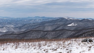 Rows of snow-covered mountain ridge lines from Round Bald on Roan Mountain. 