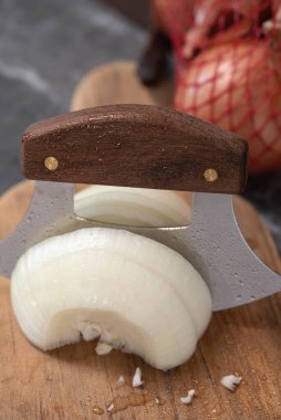Alaska Ulu Bıçağı ile tahta kesme tahtasıyla soğan dilimlemek.