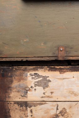 İki bölümden oluşan taşralı bir geçmişi var. Üst kısım zeytin yeşili solmuş, yırtık pırtık ve paslı metal bir desteğe sahip. Alt kısım kahverengi ve kırmızı renkte soyulmuş kağıt dokularıyla yıpranmış.. 