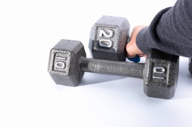 Beyaz bir arka planda, 5 kilonun üzerinde bir ağırlığa uzanan el..