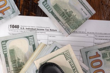 Bireysel vergi iadesi 1040 formunda 100 dolarlık banknotlar. Vergi Günü veya vergi teslim tarihi.