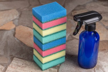 Taş bir tezgahta çevre dostu temizlik ürünleri. Sıfır atık kobalt mavi cam şişe ile biyolojik çözünebilir temizleyici, yeniden kullanılabilir sünger.