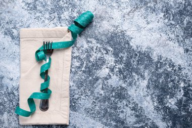 İştahını dizginle. Dalgalı bir peçeteye kıvrılmış bir çatalı saran şerit..