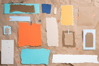 Boş, desenli, kağıt notalar, mavi, turuncu ve toprak tonlarında buruşuk kahverengi kağıt arka planda. Asgari ruh hali modeli.