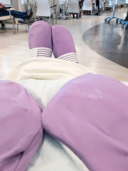 stock image Patient wearing cryotherapy gloves and booties during chemotherapy treatment to prevent acquiring peripheral neuropathy.