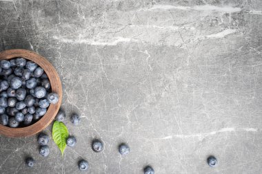 Taze, olgun yaban mersinleri ahşap bir kaseden çıkıp misket tezgahına dökülüyor..