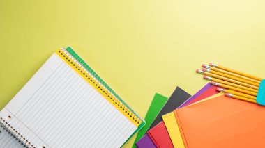 Parlak arkaplanlı öğrenci malzemeleriyle okula geri dönüyorum..