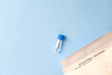 Annual Water Test Notice with sample tube on a blue background. clipart