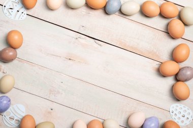 Paskalya bayramı arka planı fotokopi alanı, beyazlatılmış tahta tahtalar çok renkli yumurtalarla çerçevelenmiş..