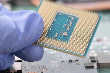 Eldivenli bir işlemci tutan bir teknisyen. Laptop bilgisayarının ana bilgisayarını bağla. Teknoloji geçmişi.