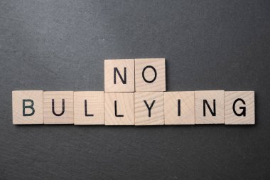 Zorbalık yok, tahta bloklar ve siyah arka planda harfler yok..