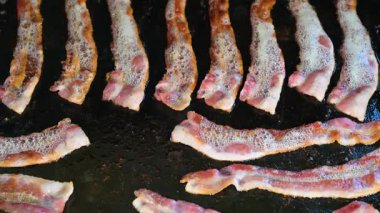 Domuz pastırması dökme demir ızgarada cızırdıyor ya da üstü düz ızgara, açık hava kampı pişirme