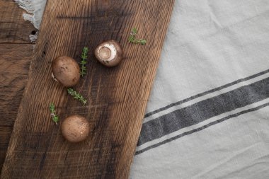 Portobello mantarı ve ahşap kesim tahtasındaki taze kekik..